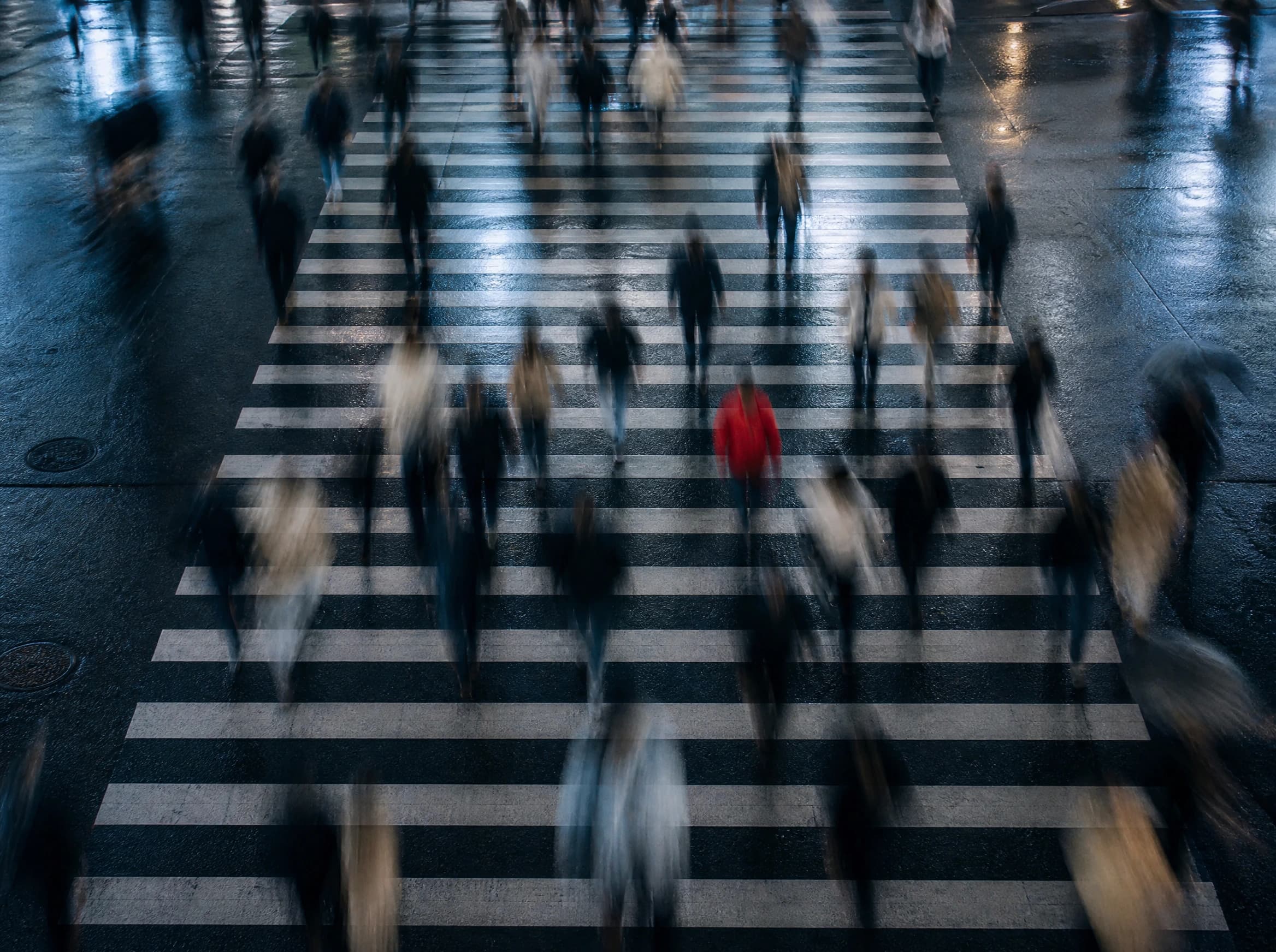 Pedestrians crossing a city street viewed with motion blur